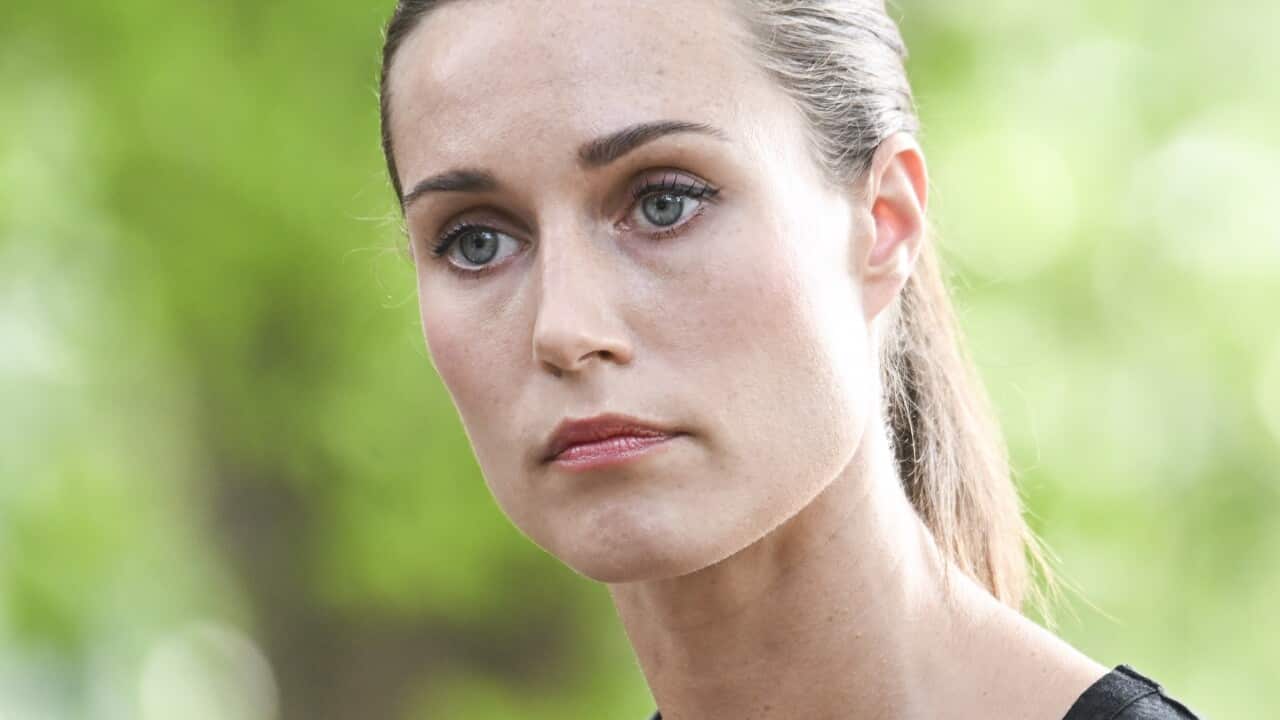 Finnish Prime Minister Sanna Marin standing outside at a press conference.