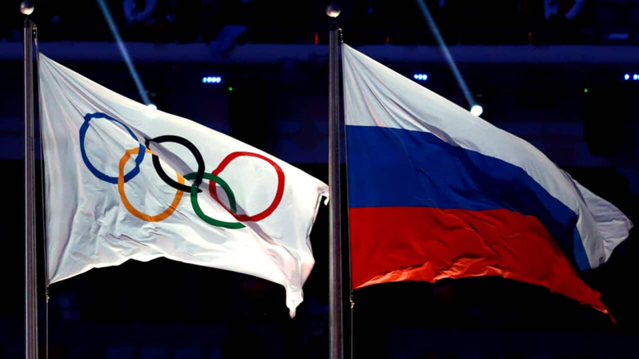 The Olympic flag flies next to the Russian flag.