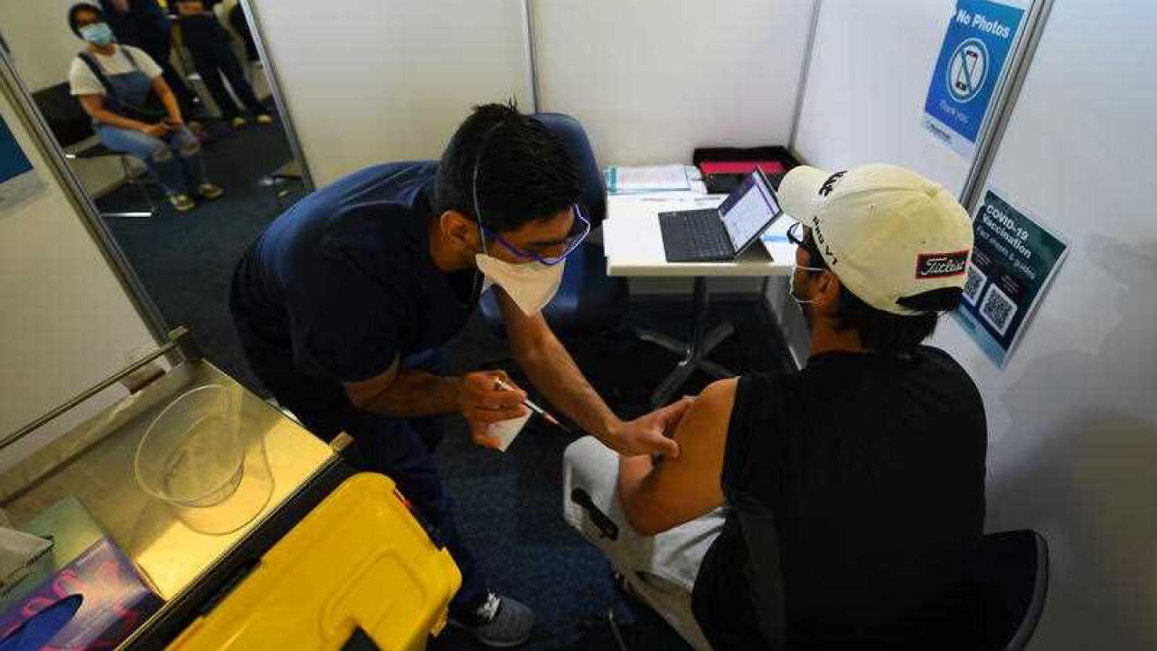 Healthcare workers administering the COVID-19 vaccine at a vaccination centre at Sandown Racecourse in Melbourne.