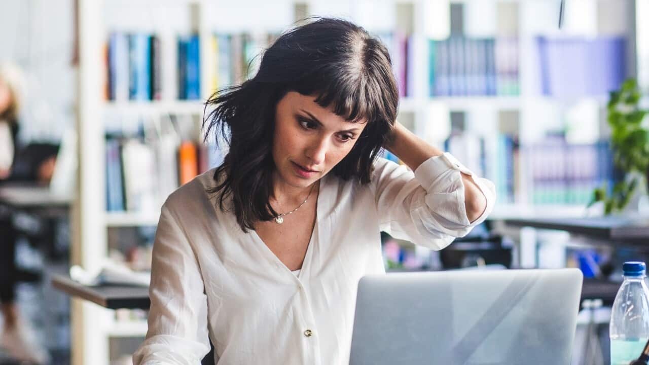 Businesswoman looking at laptop while sitting in office