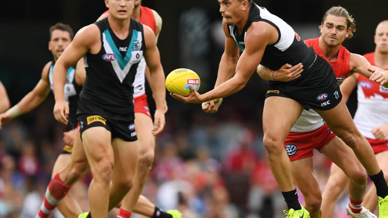 Sam Powell-Pepper of the Power gets a hand ball away