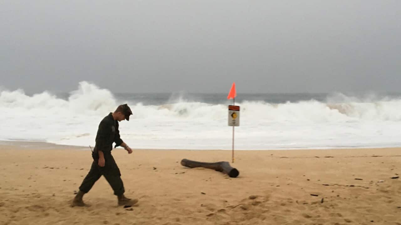 A US Marine walks on the beach at Waimea Bay in Hawaii