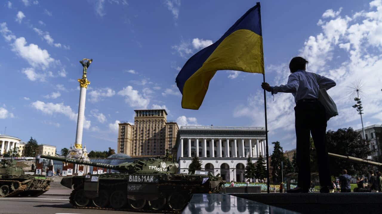 A woman holds a flag of Ukraine in Kyiv
