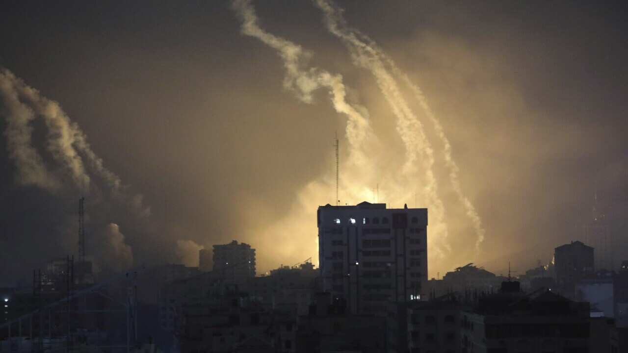 A building with smoke and flashes surrounding it