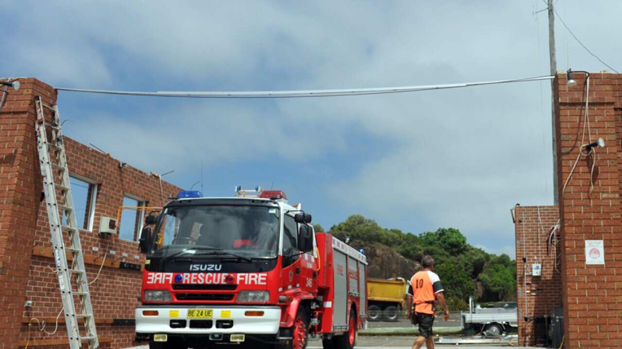 A fire engine sits in the garage of the fire station