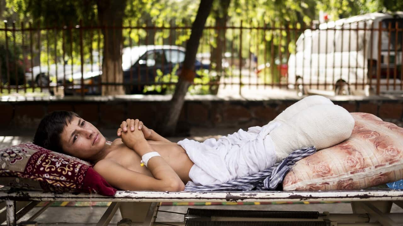Shafiqullah, 13, lies on a stretcher in the garden at Nangarhar Regional Hospital in Jalalabad, Afghanistan.