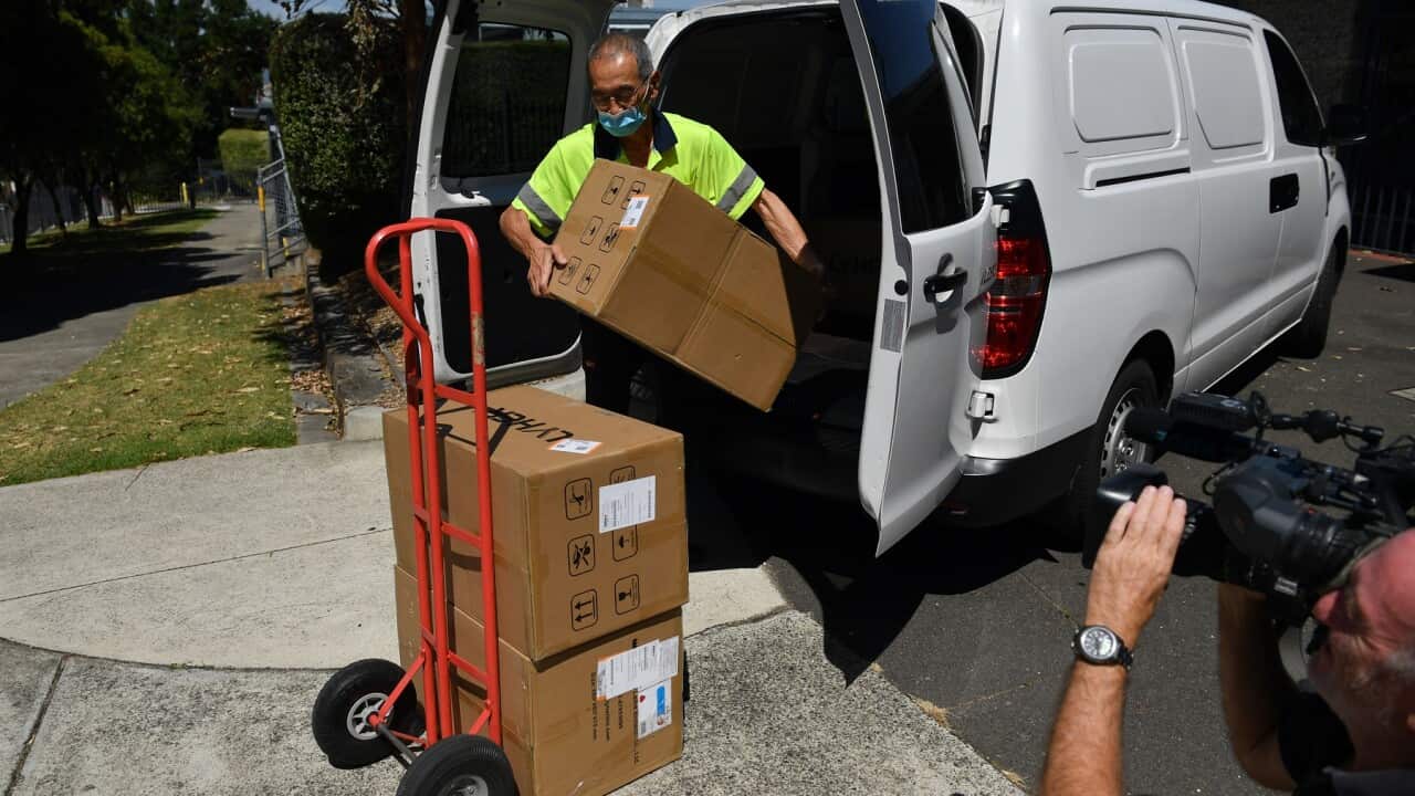 A worker delivers boxes of Rapid Antigen Tests at a primary school in Glen Waverley, Melbourne