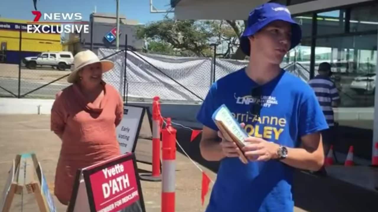 Disgraced Young Liberal, Jake Scott stands beside Redcliffe candidate, Kerri-Anne Dooley as he hands out voting cards.