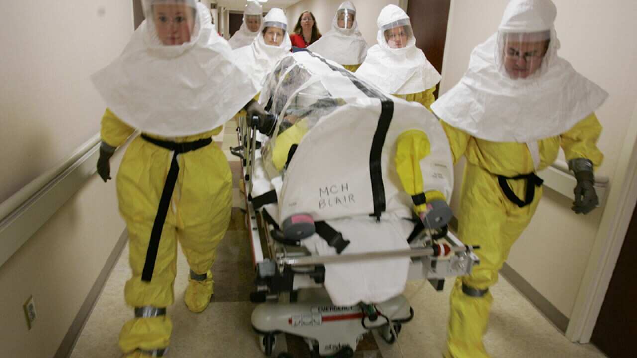 a mock patient is wheeled in an isolation pod