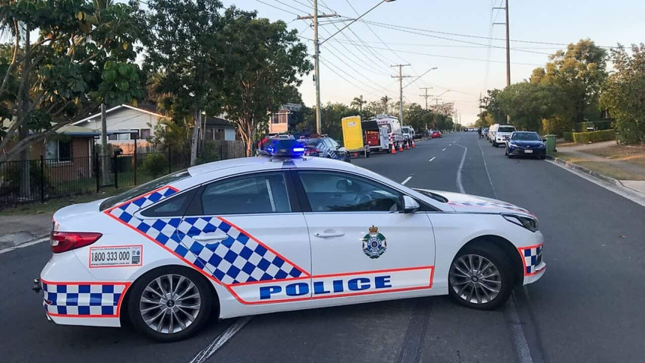 Police forensics examine a vehicle outside a property in Logan, south of Brisbane.