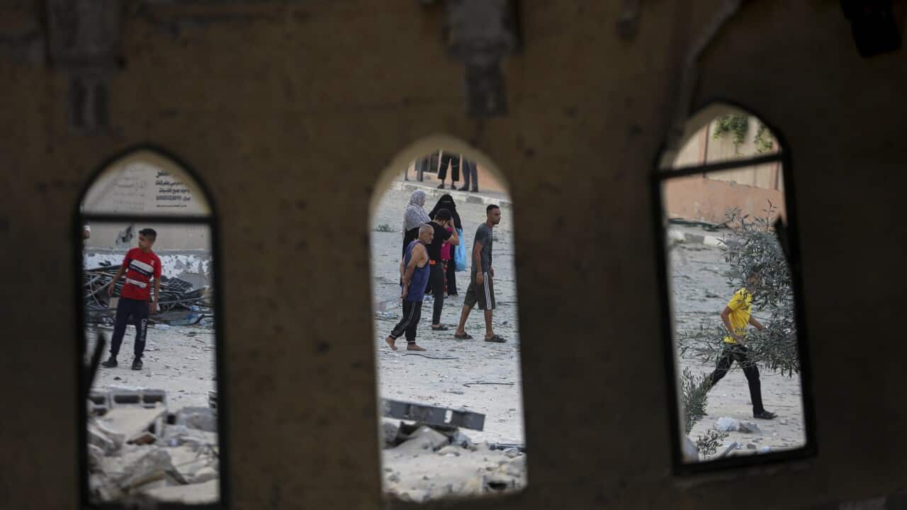 People stand outside a mosque destroyed in an Israeli air strike in Khan Younis, Gaza Strip