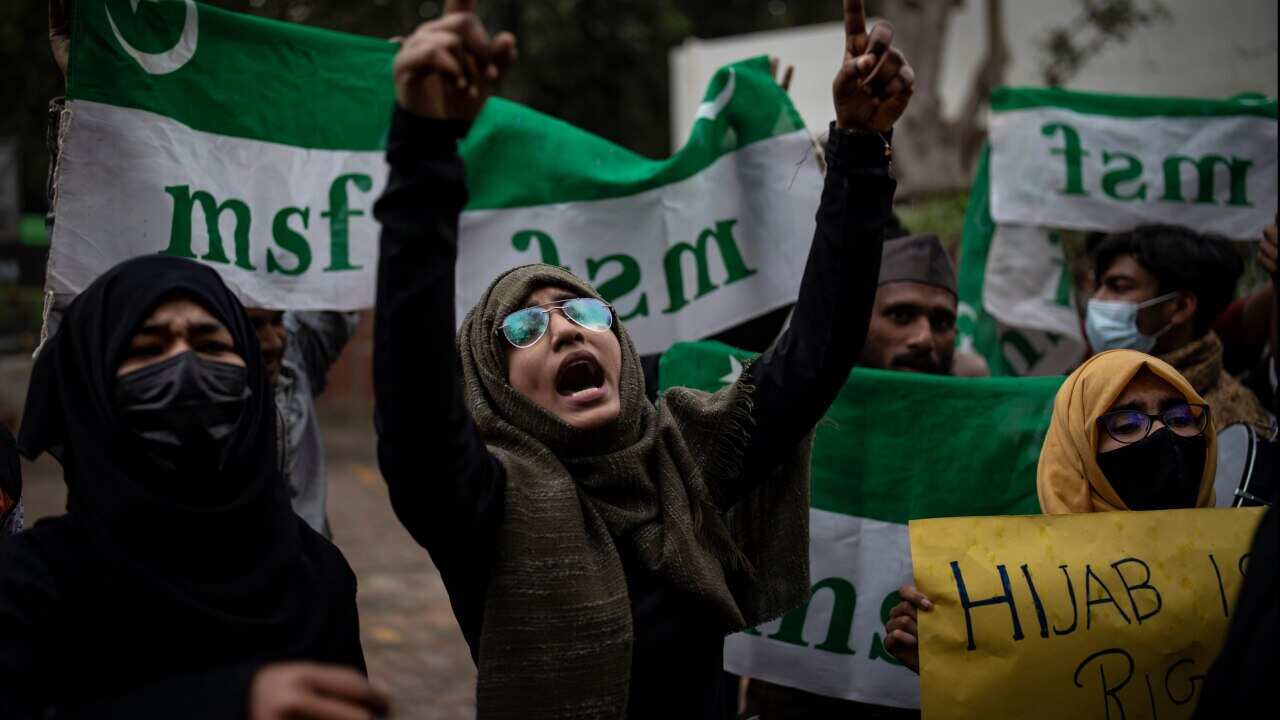 An Indian Muslim woman shouts slogans during a protest against barring Muslim girls wearing hijab
