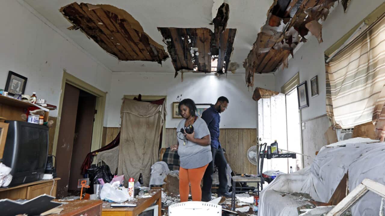 A woman salvages possessions after a tornado in Mississippi