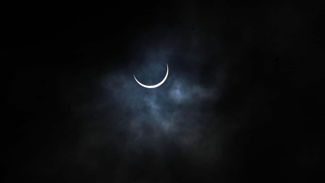A view of the partially eclipsed sun seen in an overcast sky during the annular solar eclipse, at India Gate, on June 21, 2020 in New Delhi, India.