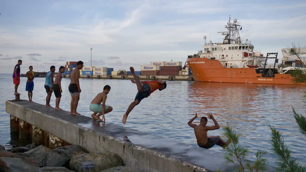 Teenagers jump into the ocean at Avatiu Harbour, Rarotonga.