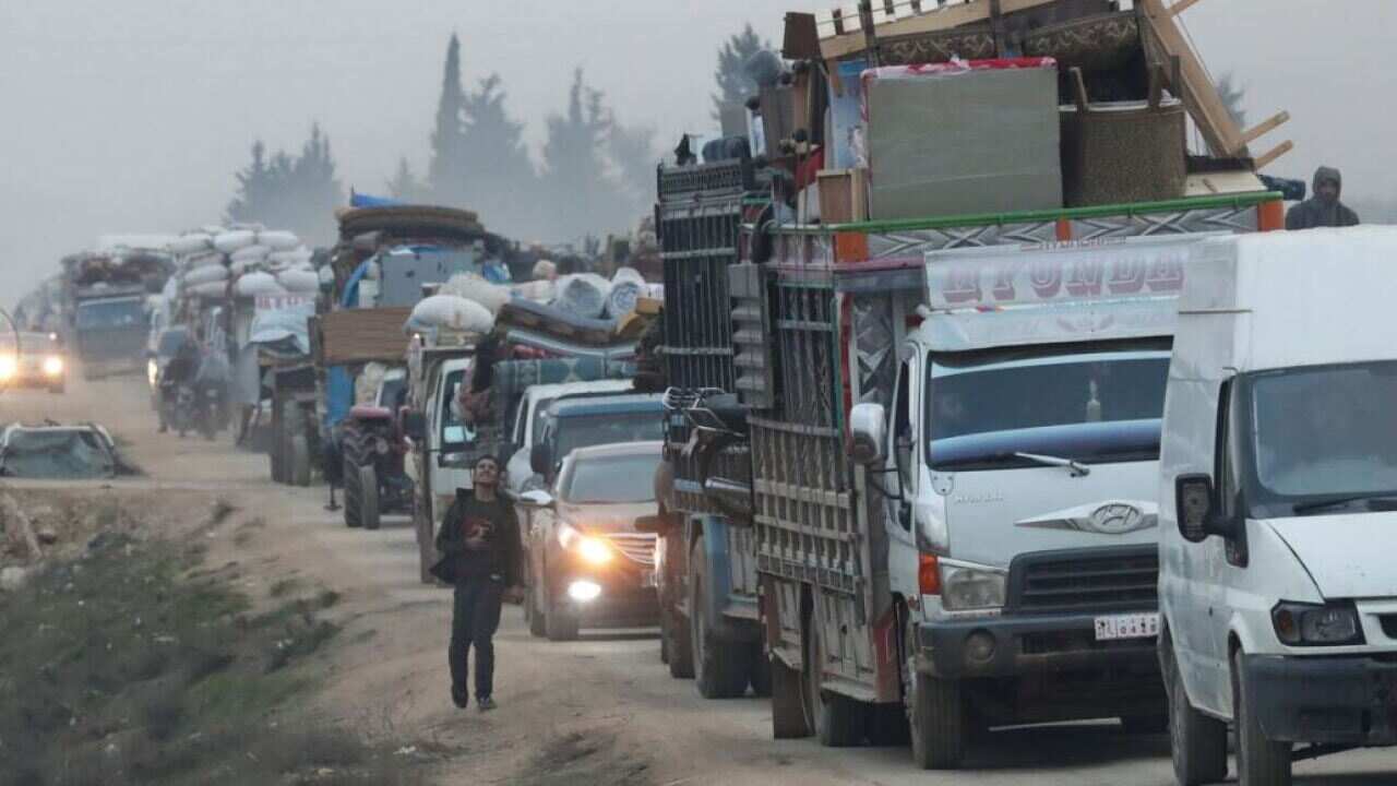 Trucks carrying displaced Syrians and their possessions as they flee nearby fighting.