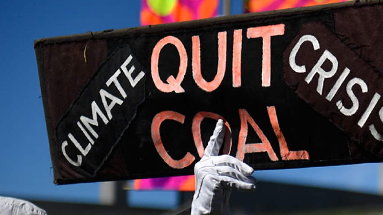 Protesters hold signs and banners at a Stop Adani Mine rally on the lawns of Parliament House in Canberra, Monday, February 5, 2018.