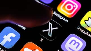 A finger touches applications on a smartphone screen
