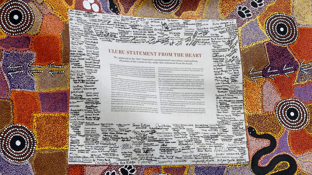A document surrounded by signatures embedded in a traditional First Nations dot painting