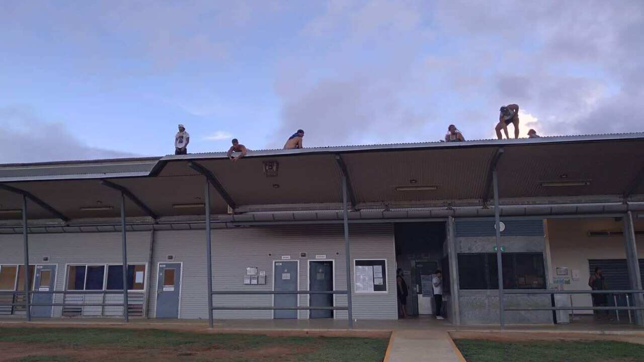 Detainees are shown on a roof at Christmas Island on Tuesday.
