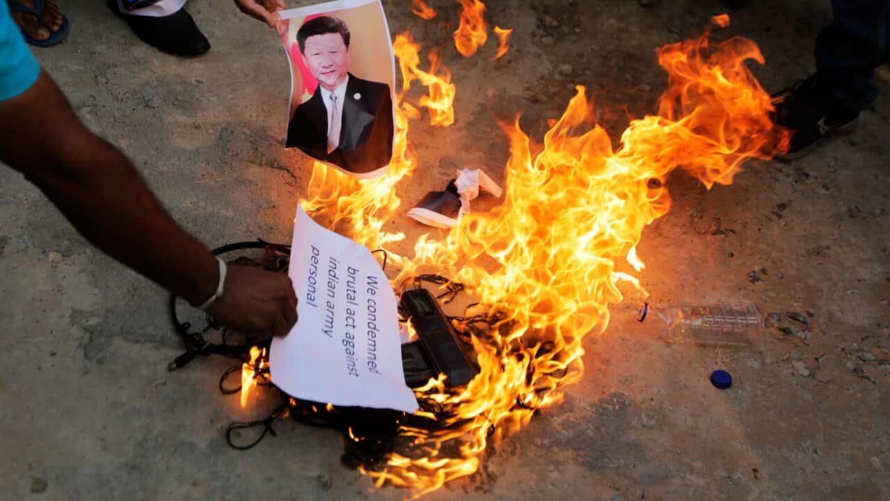 An Indian man burns a photograph of Chinese president Xi Jinping during a protest against China in Ahmedabad, India.