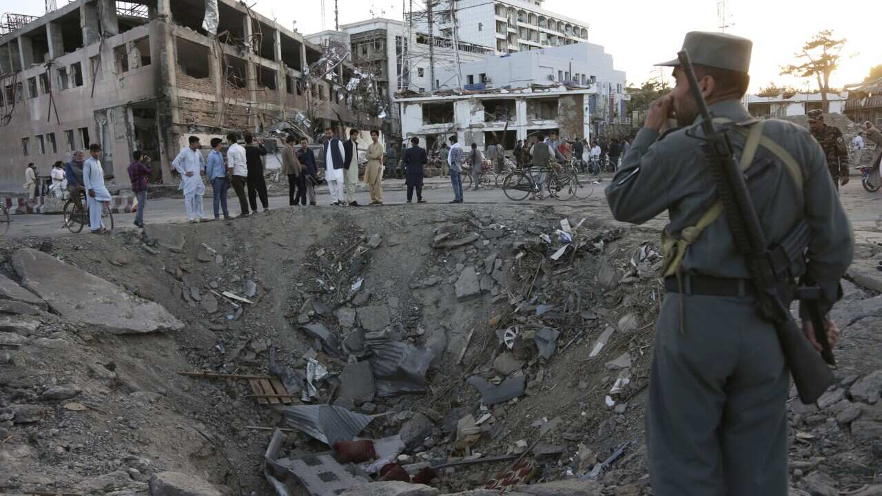In this Wednesday, May 31, 2017 file photo, security forces stand next to a crater created by a massive explosion, that killed over 150 according to the Afghan president,