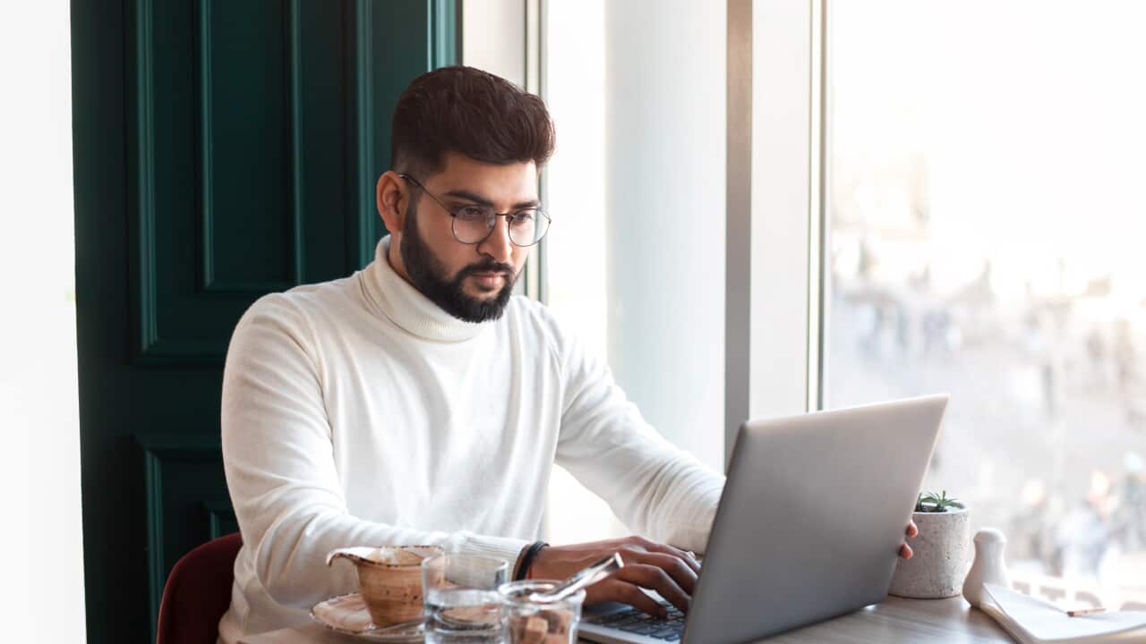 Handsome businesman sitting in cafe and working.