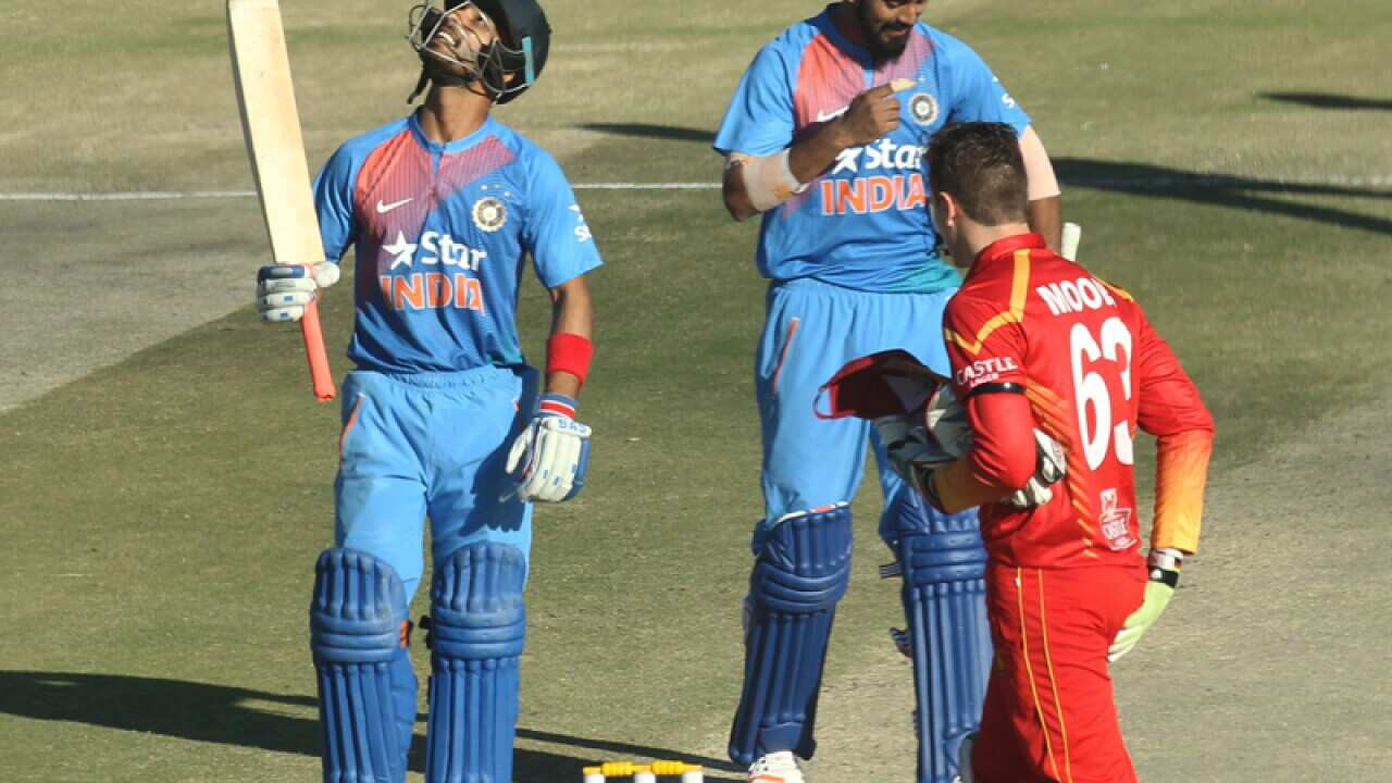 Indian batsman Mandeep Sing raises his bat after scoring 50 runs