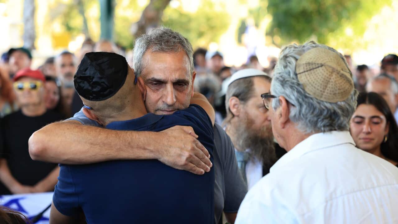 Two men hugging among a crowd of people.