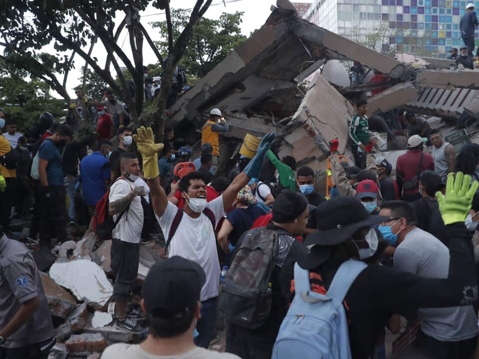 Rescue workers operate at the site of a collapsed building following an earthquake in Cali, Colombia (AAP)