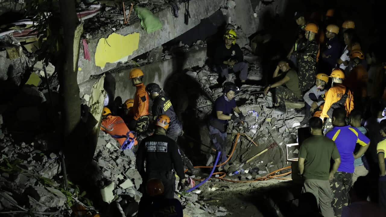 Emergency responders continue search operations at a damaged commercial building following an earthquake in Porac town, north of Manila, Philippines