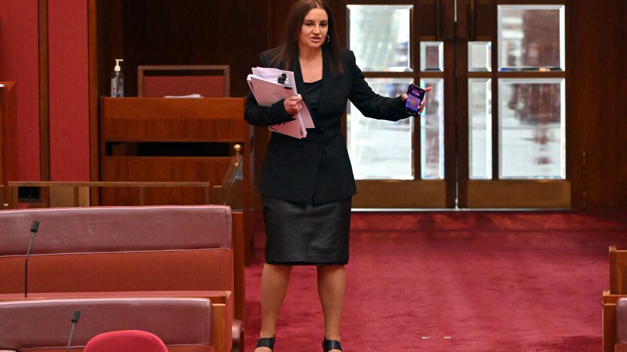 Woman in black stands in the Senate.