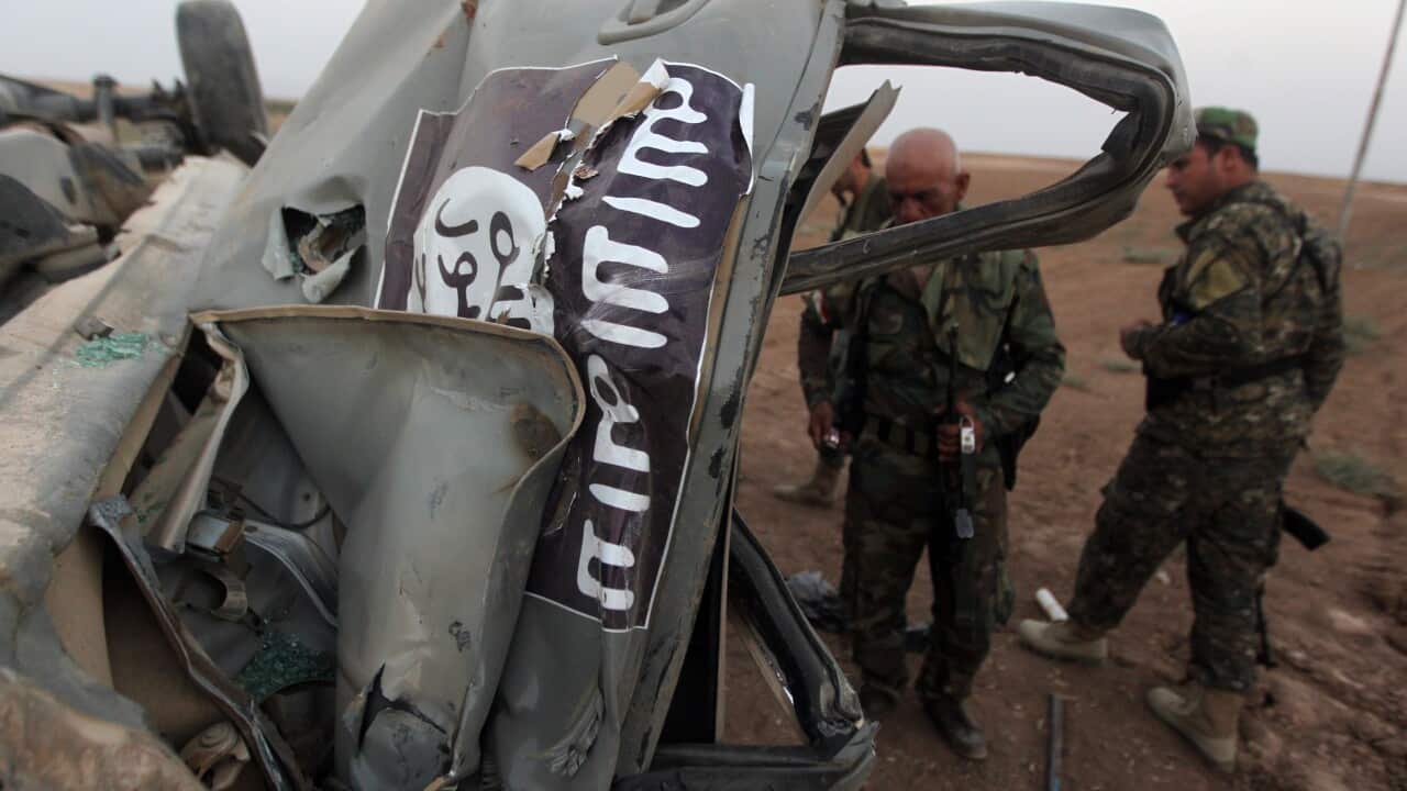 The remains of a car, bearing an image of the IS flag, after it was targeted by an American air strike 