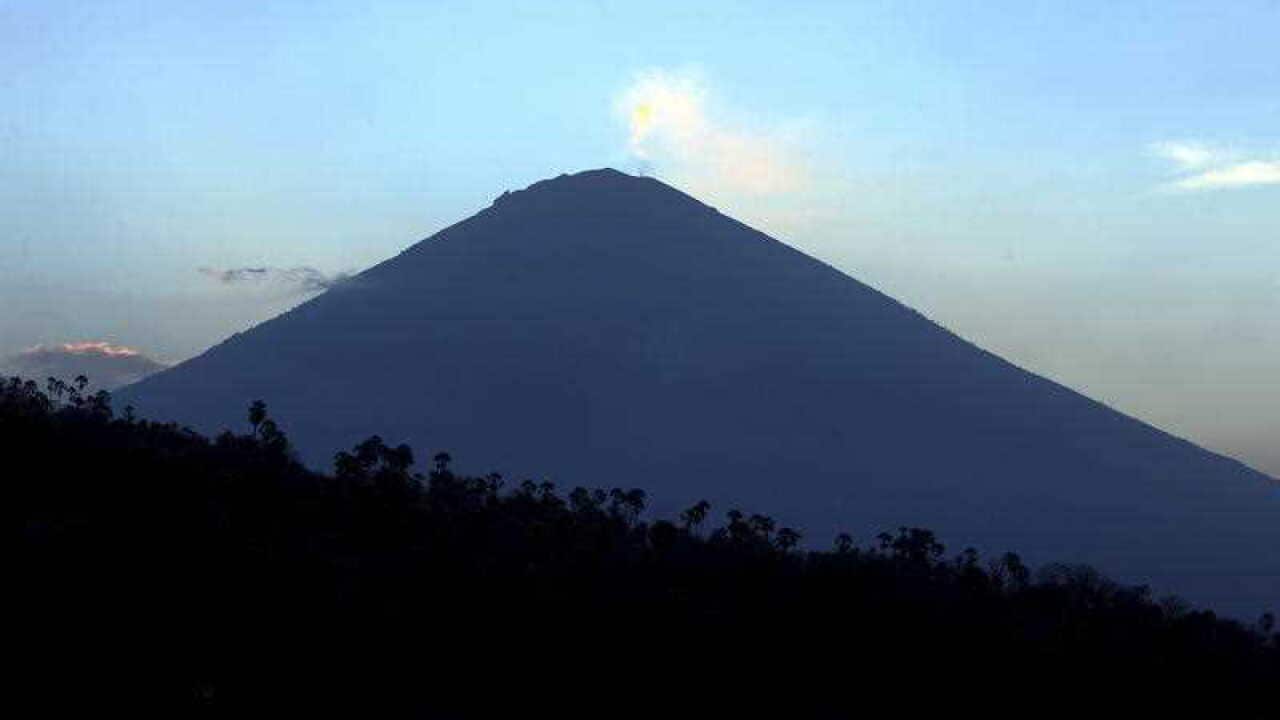 Mount Agung volcano is seen at sunset in Karangasem, Bali, Indonesia, Thursday, Sept. 28, 2017. More than 120,000 people have fled the region around the Mount Agung volcano on the Indonesian tourist island of Bali, fearing it will soon erupt.