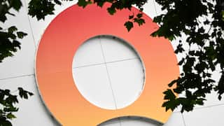 A large orange logo affixed to beige building panels.