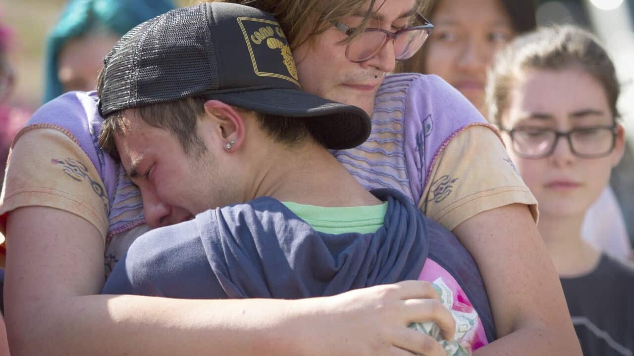 Mourners hug at a memorial for Georgia Tech student Scout Schultz
