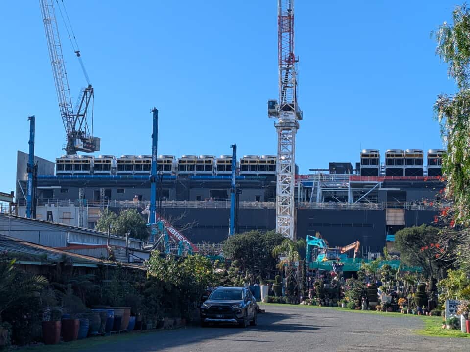 A large building under construction in a suburban street.