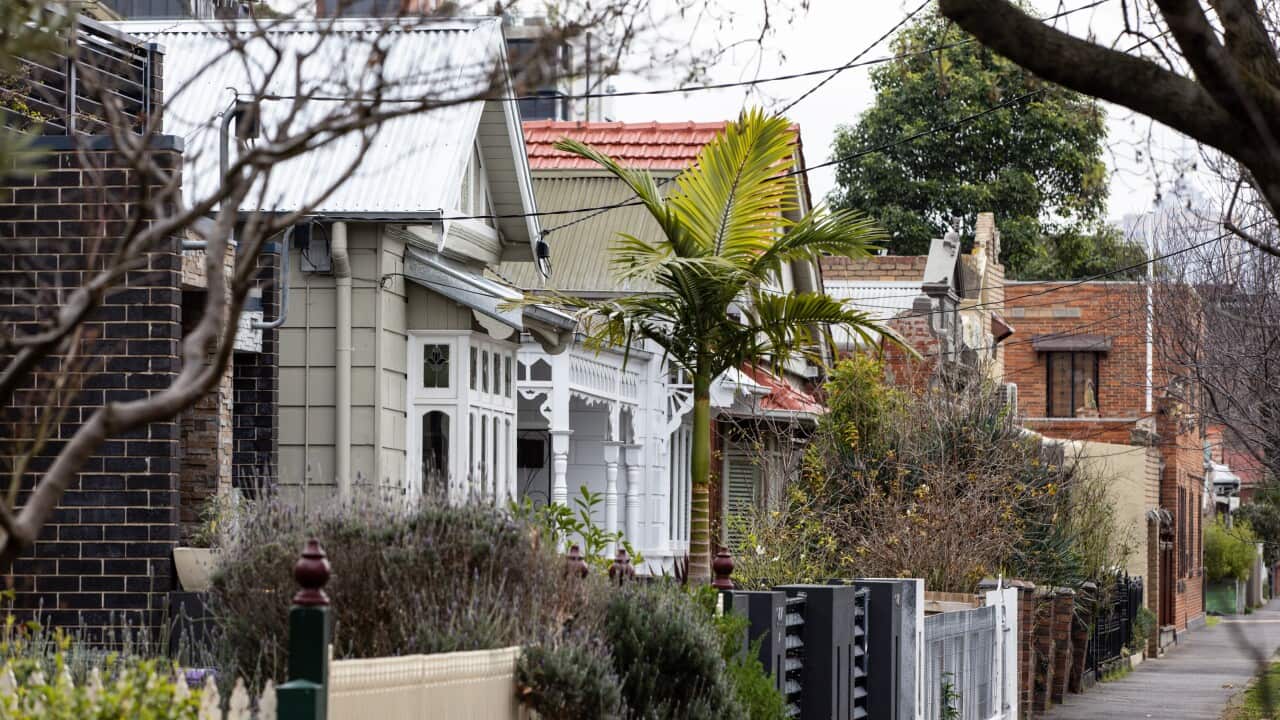 Woman walking in front of the Reserve Bank of Australia sign.