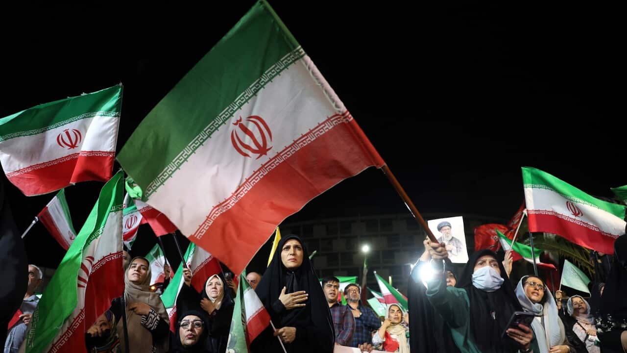 Iranians wave national flags at a rally following Iran’s attack on Israel.jpg
