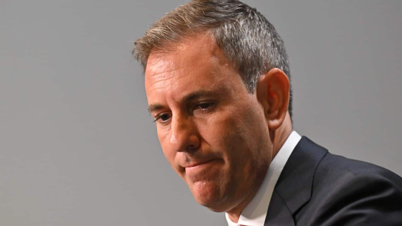 A man in a suit and tie at a press conference.