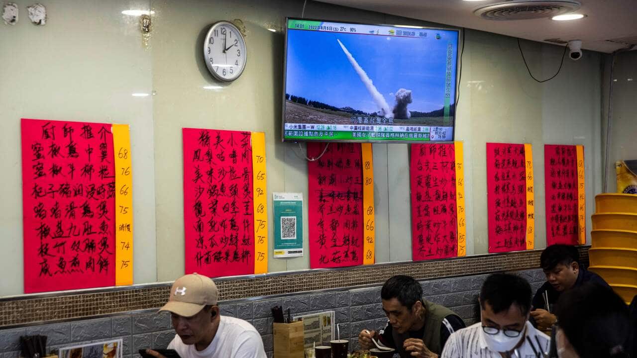 A television (top) in a restaurant in Hong Kong on 5 August, 2022, shows a missile being launched during military exercises being held by China around Taiwan.