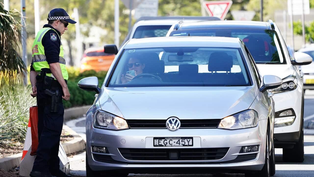Motorists are seen at a checkpoint at Coolangatta on the Queensland border in August