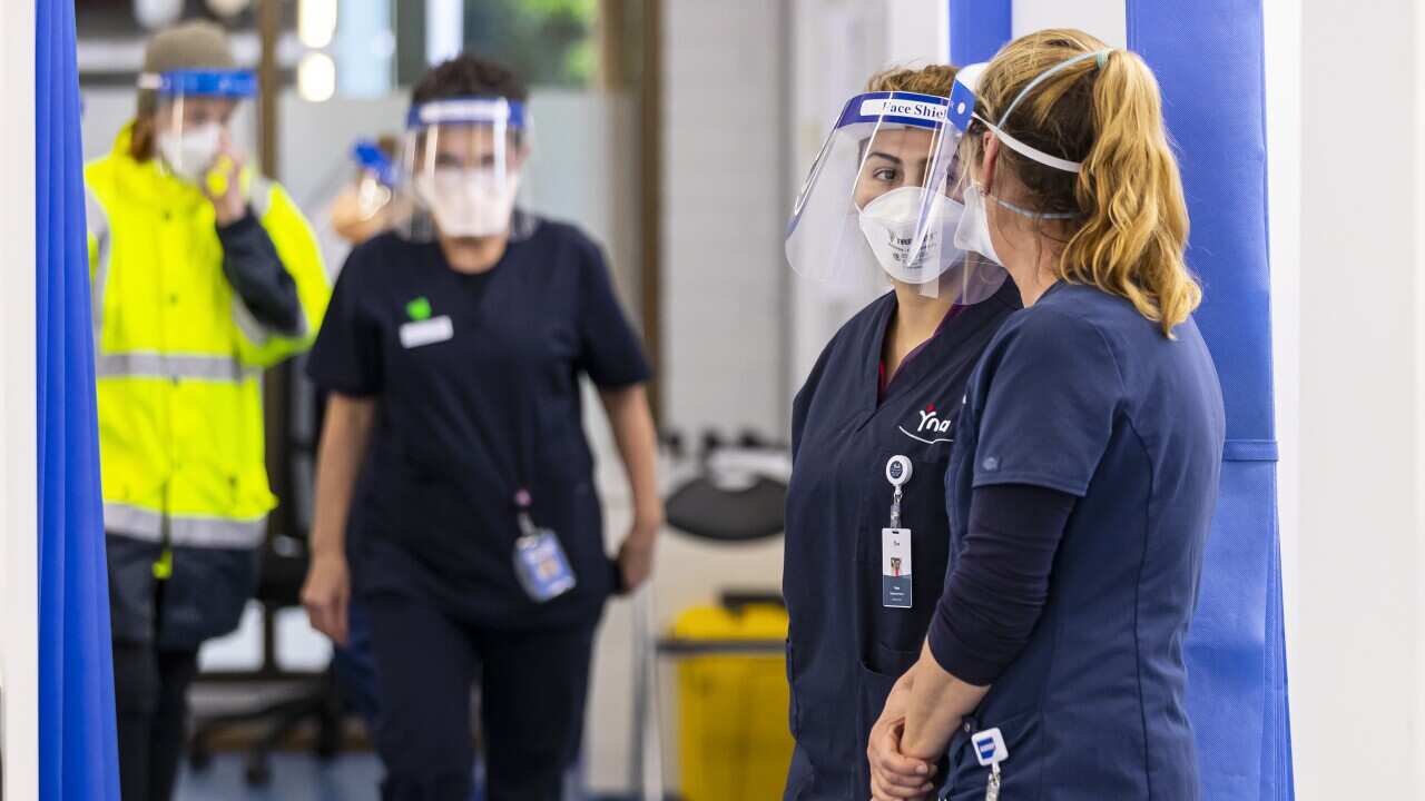 Four people wearing PPE in a hospital