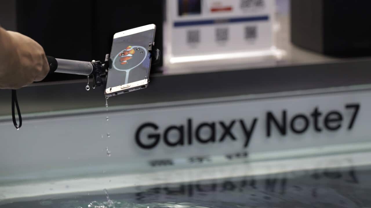 A man tries out the Samsung latest smartphone Galaxy Note 7 at a roadshow booth outside a shopping mall in Beijing.