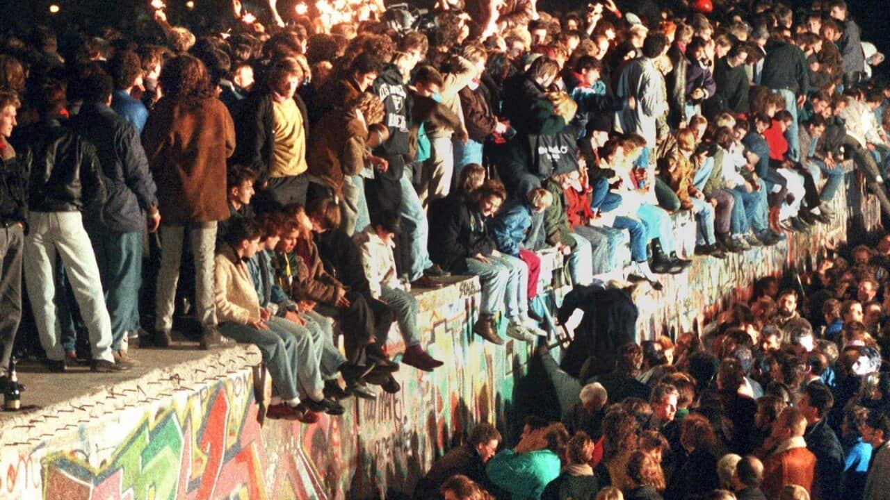 A file picture from November 1989 shows people celebrating the fall of the Berlin Wall