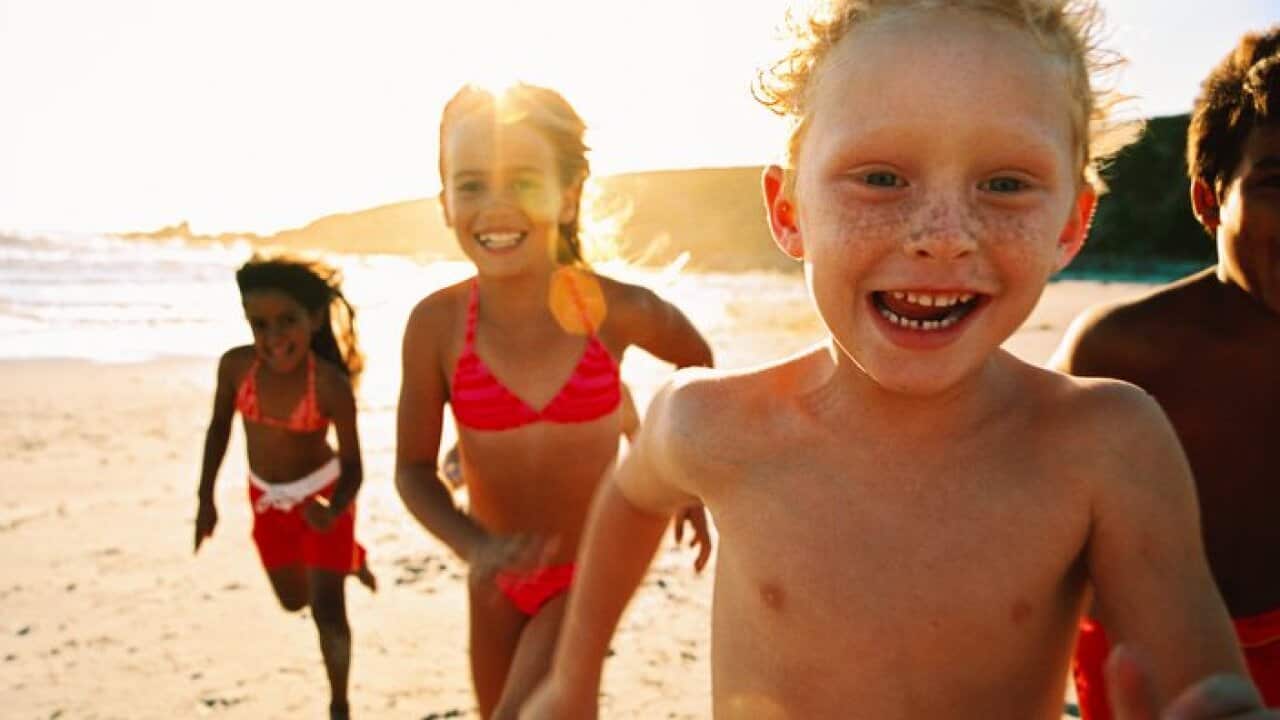 portrait of a group of children running on the beach