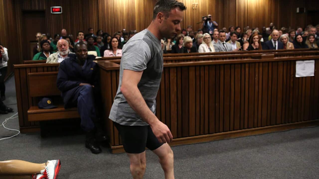 Oscar Pistorius walks across the courtroom without his prosthetic legs