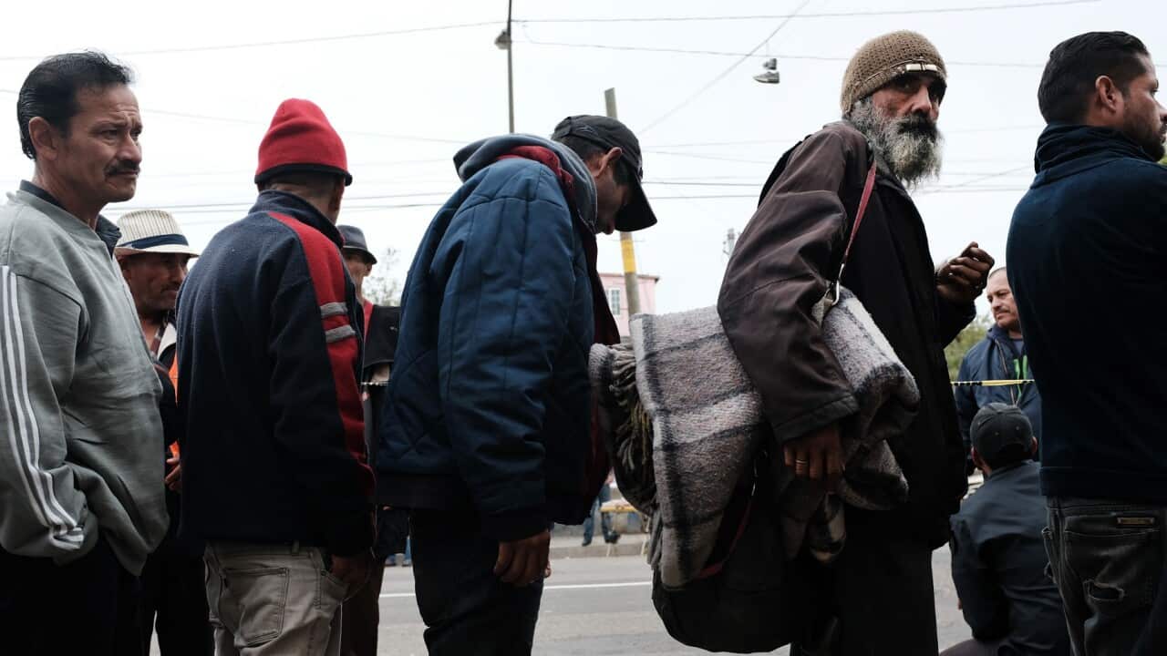 Homeless men deported from the US queue for food handouts in Tijuana, Mexic