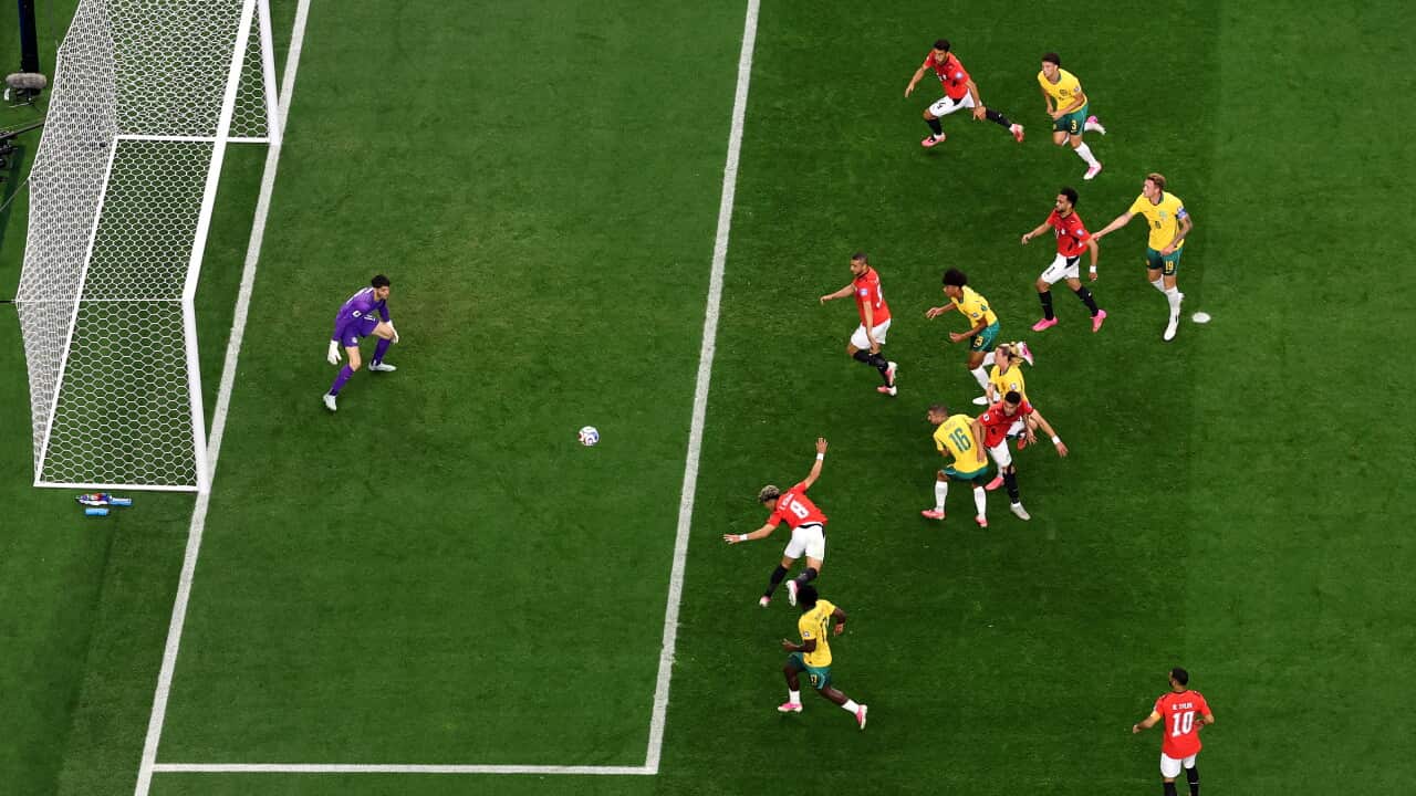 An aerial shot of football players in red shirts and yellow shirts