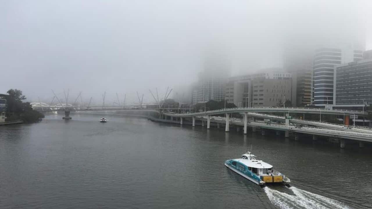 Commuters on Victoria Bridge are seen shrouded in fog.
